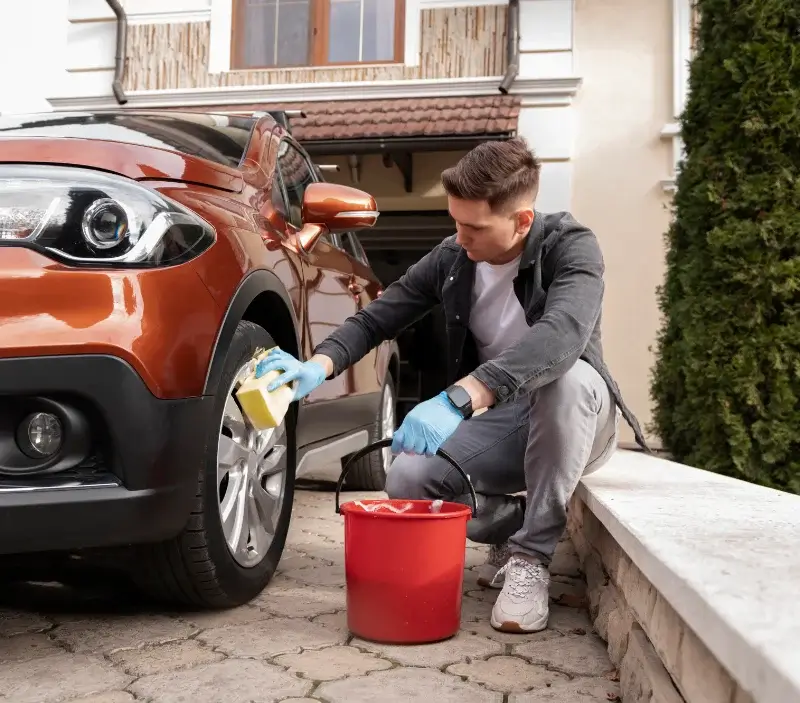 Lavage auto à domicile La Muraz : professionnel intervenant sur un véhicule